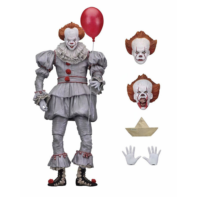 Action figure of a clown with a red balloon, including interchangeable faces and accessories, on a white background.