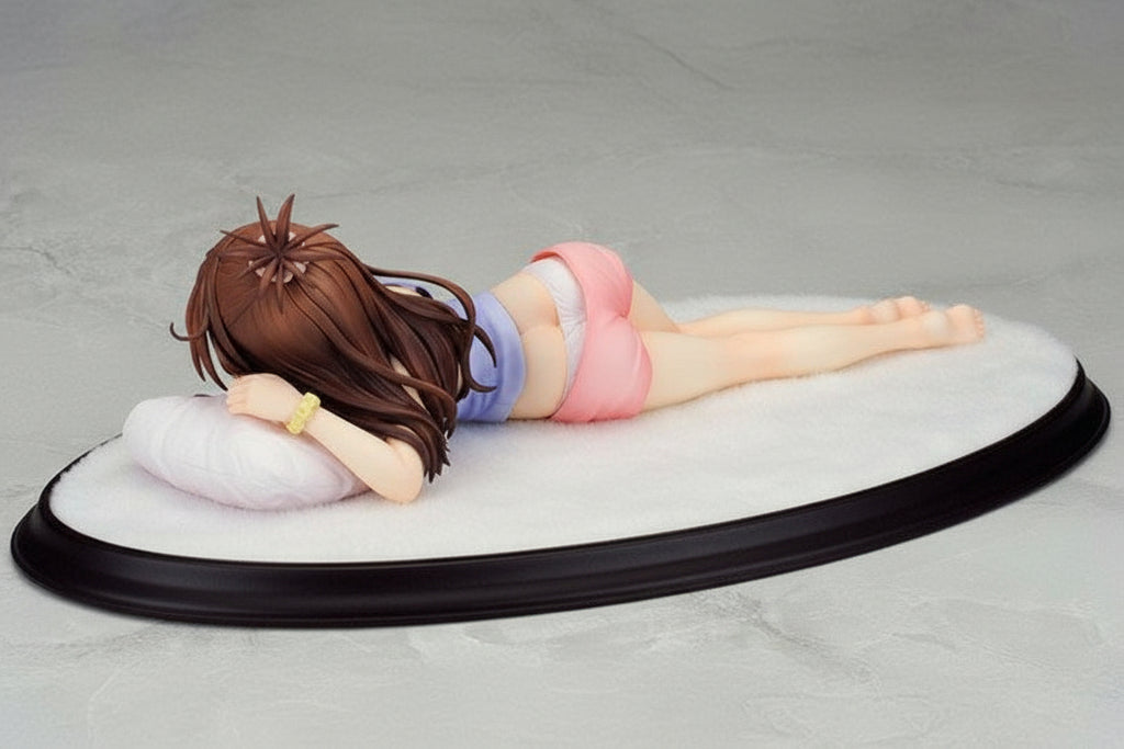 Figurine of a person lying down on a gray surface