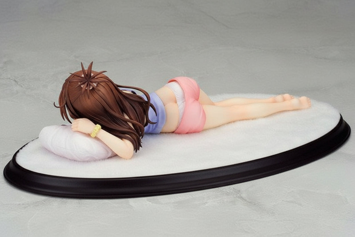 Figurine of a person lying down on a gray surface
