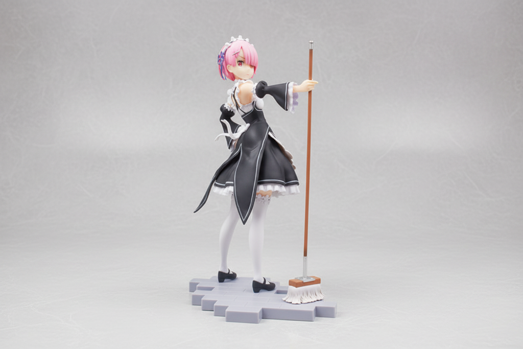 Anime character figurine with pink hair and a staff on a dark background