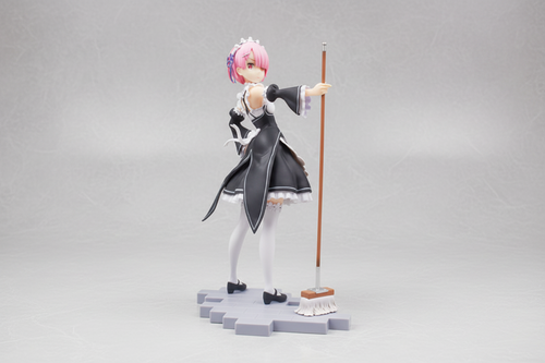 Anime character figurine with pink hair and a staff on a dark background